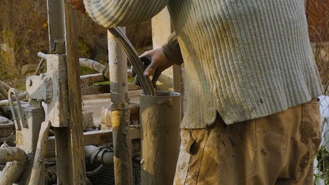 The worker, with his bare hands, takes out a dirty hose from a pipe. Dirt sticks Stock-Footage 122324485