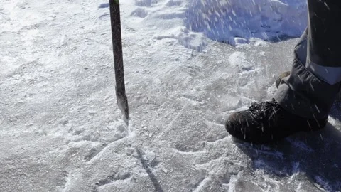 The worker hits the ice with a crowbar and splashes and snow crystals fly. Close Stock Footage 151758688