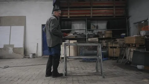 A worker hits metal with a hammer Stock Footage 265190460