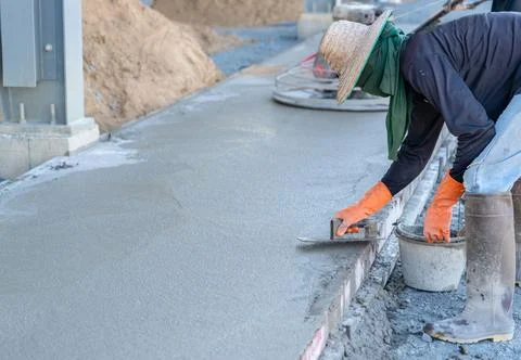 Worker hold trowel plastering surface concrete floor. Stock Photos