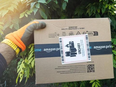 Worker Holding Amazon Box with UN3481 Battery Sticker Stock Photos