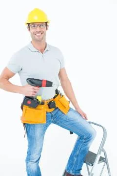 Worker holding drill machine on step ladder Stock Photos