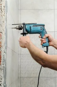 The worker holding a drill. Stock Photos