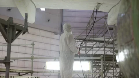 Worker Holding a Hose In a Hangar next to Airbus a320 In A Hangar Paintshop Stock Footage 231648277