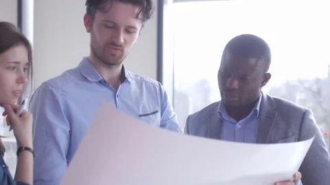 Worker holding a large sheet of paper thinking about economic results Stock Footage 73866919
