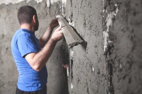 Worker holding level tool. Plastering wall. Construction work Stock Photos