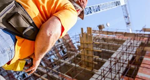 Worker is holding remote, wireless, control for overhead crane at building si Stock Photos