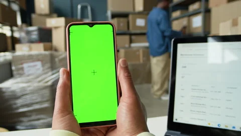 Worker Holding Smartphone with Green Screen in Logistics Warehouse Stock Footage 337310305