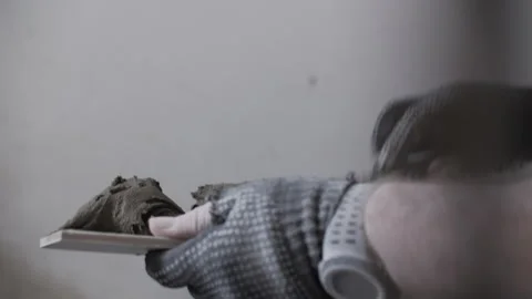 Worker holding tile adhesive on trowel before application Stock Footage 320786193