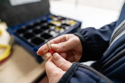 Worker holding wire ferrule performing electrical connection Stock Photos