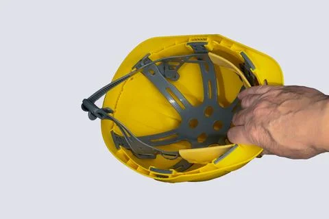 Worker holding a yellow hard hat for safety at work Stock Photos