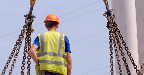 Worker hooks crane hooks to a massive load and carries it to the right place Stock Footage 147638021