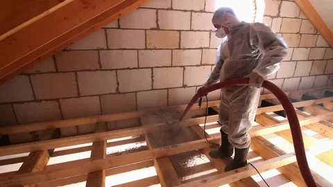 Worker with a hose is lays cellulose insulation in the attic of a house Stock Footage 144735719