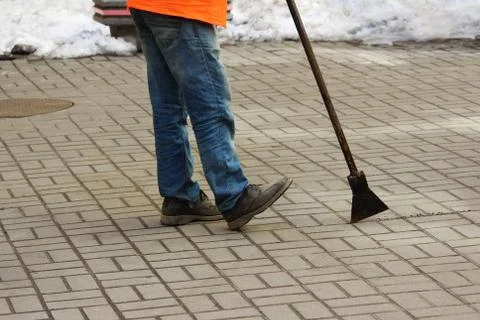 Worker with an ice pick in his hands clears the inner courtyard Stock-Fotos