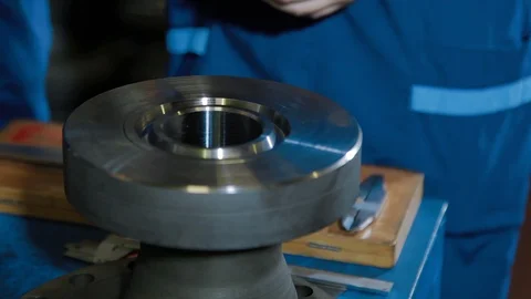 Worker in industrial company checking quality Parts of wellhead fittings and Stock Footage 127555866