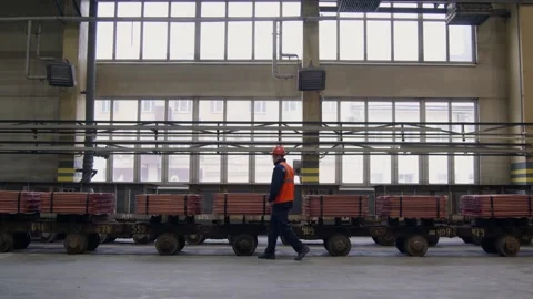 Worker in an Industrial Facility with Mining Carts Engaged in Various Activities Видео 301389356