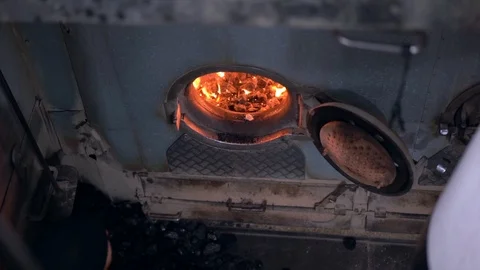 A worker insert a coal inside the engine of coaled power steam ship Stock Footage 123515804