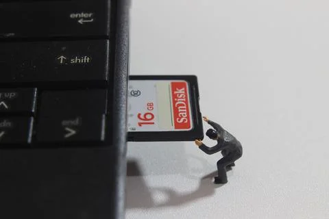 Worker inserting Sandisk 16 GB SD Card into Notebook Slot Stock Photos