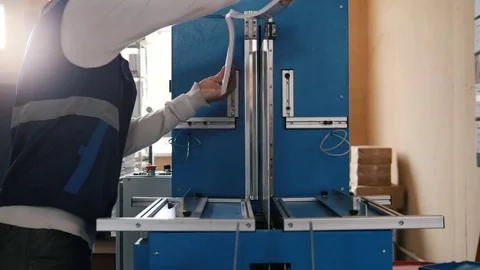 Worker inserts sheets of paper to printing machine, polygraph industry Stock Footage 76960906