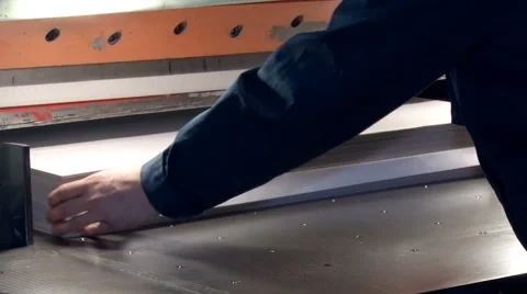 The worker inserts the stack of paper in the machine for cutting uneven edges Stock Footage 64389950