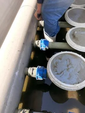 Worker Inspecting Aerator Diffuser System in Wastewater Treatment Facility .. Stock Photos