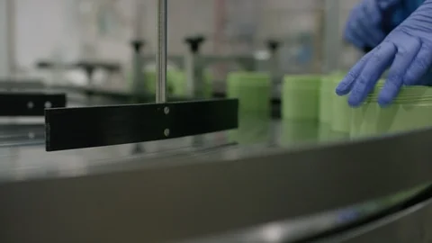 Worker inspecting cosmetic boxes on conveyor belt in factory Stock Footage 107956977