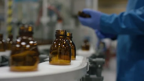 Worker inspecting empty bottles on production line in cosmetic factory Stock Footage 107979265