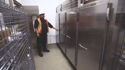 Worker inspecting new kitchen refrigerator appliances in new house or business Vidéo 70459828