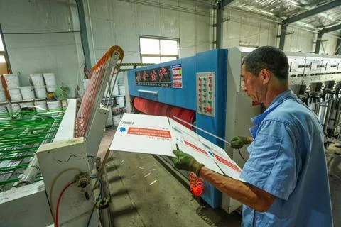 Worker Inspecting Printed Carton Samples in Carton Printing Workshop Stock Photos