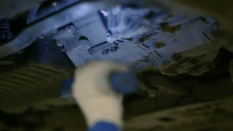 The worker inspects the bottom of the car with a lantern. Stock Footage 80469932