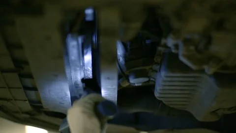 The worker inspects the bottom of the car with a lantern. Stock Footage 80469934