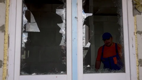 Worker inspects broken glass, vandals broke glass Stock Footage 115438064