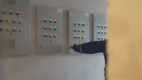 Worker inspects open electrical panel and closes using key Stock Footage 311106680