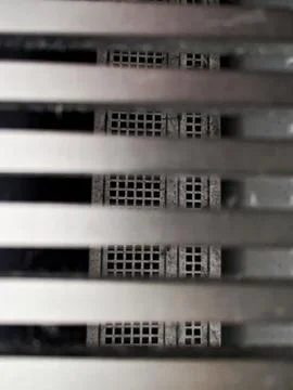 Worker Inspects Shadowed Cavity And Dust Buildup Within Narrow Metallic Slats Stock Photos
