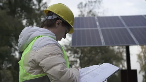 Worker inspects solar panels and writes information in a notebook. Stock Footage 144357767