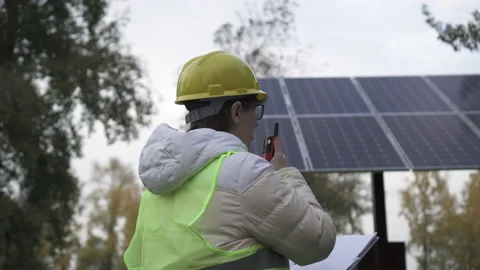 Worker inspects the solar panels and reports the information to the management Stock Footage 144357817