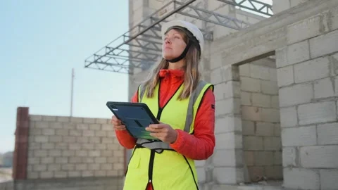 Worker inspects structure, updating tablet documentation while walking. Stock Footage 307888694