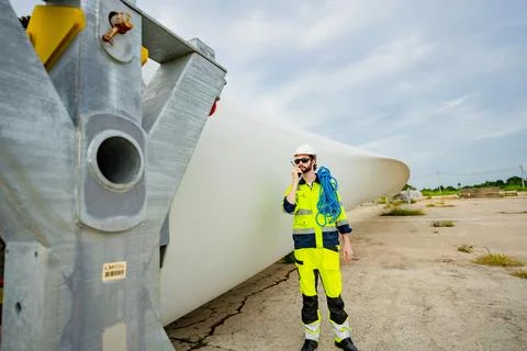 Worker inspects wind turbine components at installation site in the afterno.. Stock Photos
