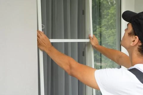 A worker Install Mosquito Net on Windows. Protection from flying insects Stock Photos