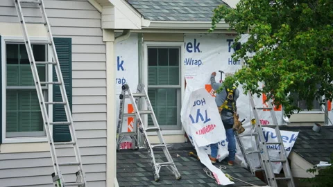 A worker install new siding outside walls of the private house. Naperville IL Stock Footage 327166305