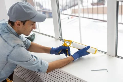 The worker installing and checking window in the house Stock Photos