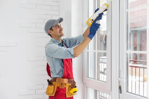 The worker installing and checking window in the house Stock Photos