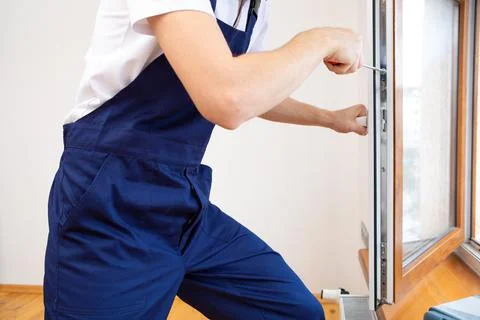The worker installing and checking window in the house Stock Photos