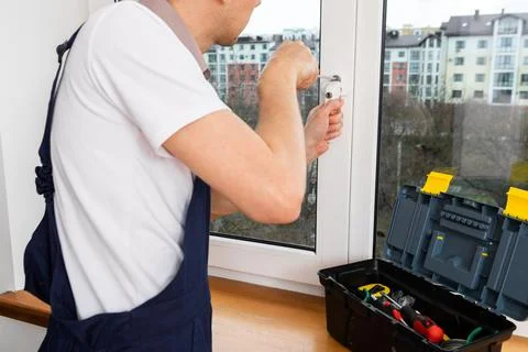 The worker installing and checking window in the house Stock-Fotos