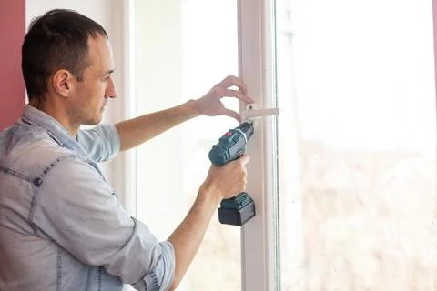 The worker installing and checking window in the house. Foto stock