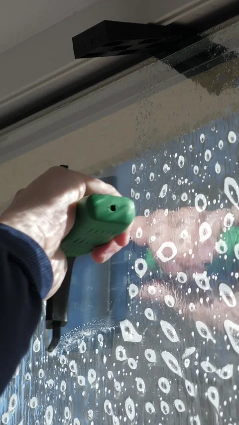 Worker installing and smoothing tint film on window at home. Man tinting windows Stock Footage 327097928