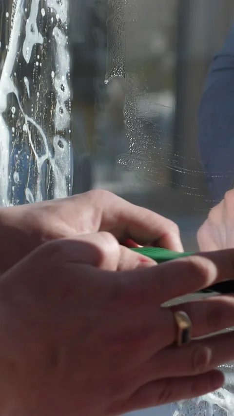 Worker installing and smoothing tint film on window at home. Man tinting windows Stock Footage 327097955