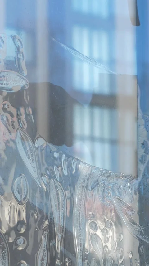 Worker installing and smoothing tint film on window at home. Man tinting windows Stock Footage 327126029