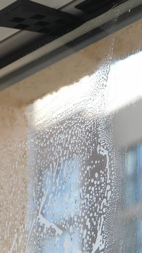 Worker installing and smoothing tint film on window at home. Man tinting windows Stock Footage 327128551