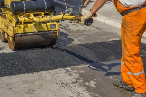 Worker installing asphalt speed bump Stock Photos